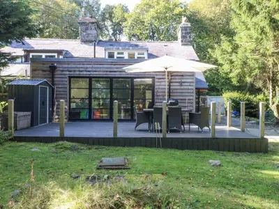a house with an outdoor patio with an umbrella at Islwyn in Bala