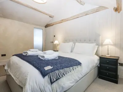 a bedroom with a large white bed with towels on it at Islwyn in Bala