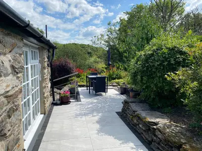 a pathway leading to a house with a table and plants at Garth Engan B&B with private lounge in Llanbedr