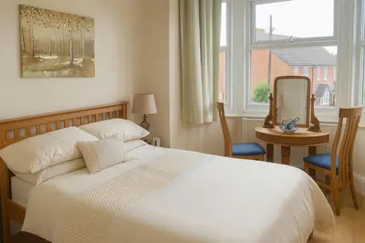 a bedroom with a white bed and a table and a mirror at The Boughton Peterchurch - Pub Grub & Bed in Peterchurch