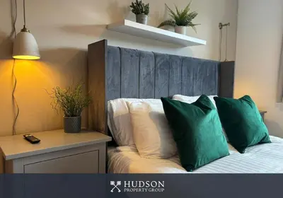 a bedroom with a bed with green pillows on it at 3 Bedroom Modern Property with Parking in Shrewsbury
