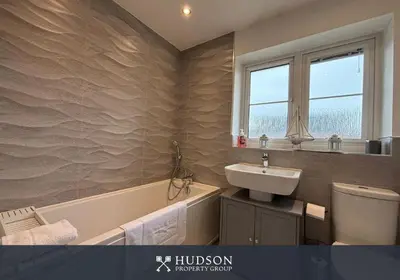 a bathroom with a sink and a bath tub at 3 Bedroom Modern Property with Parking in Shrewsbury