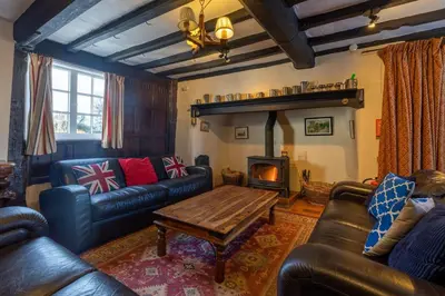 a living room with couches and a table and a fireplace at RYTON GRANGE FARMHOUSE to sleep 12 in Shrewsbury