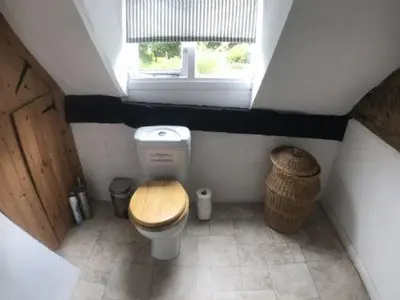 a small bathroom with a toilet and a window at RYTON GRANGE FARMHOUSE to sleep 12 in Shrewsbury
