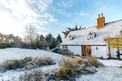 an old house with snow on the ground at RYTON GRANGE FARMHOUSE to sleep 12 in Shrewsbury