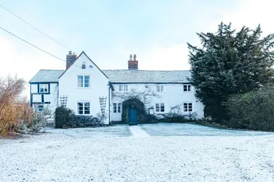a large white house with a blue door at RYTON GRANGE FARMHOUSE to sleep 12 in Shrewsbury