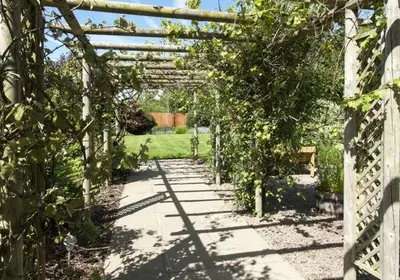 a pergola in a garden with a pathway at Countryside home 5 minutes from Ludlow - Pass the Keys in Ludlow