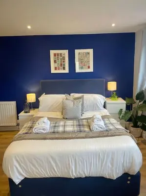 a blue bedroom with a large bed with towels on it at Pet friendly, spacious house, sleeps 6 in Llanbadarn-fawr