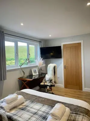 a bedroom with two beds and a desk and a window at Pet friendly, spacious house, sleeps 6 in Llanbadarn-fawr