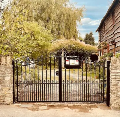 a black gate with a car parked in a driveway at Tawny Owl Barn in Leintwardine