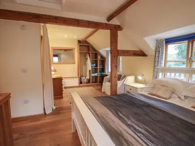 a bedroom with a large bed in a room at New Inn Cottage in Church Stretton