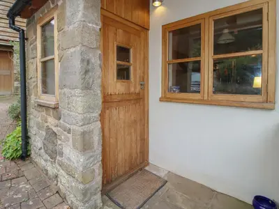 a wooden door and windows on a house at New Inn Cottage in Church Stretton