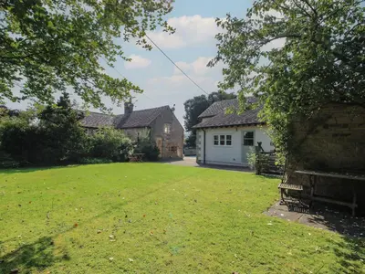 a yard with a house and a white garage at New Inn Cottage in Church Stretton