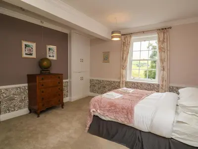 a bedroom with a bed and a window at Llwynderw Hall in Llanwrtyd Wells