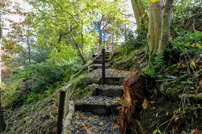 a set of stairs on a trail in the woods at Nant Gwenyn - Hafan Hideaways Eryri in Llanymawddwy