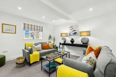 a living room with couches and yellow accents at Bell Cottage by Ludlow Castle with onsite parking in Ludlow