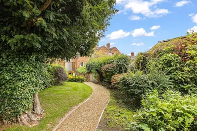 a path in a garden with a house in the background at Bell Cottage by Ludlow Castle with onsite parking in Ludlow