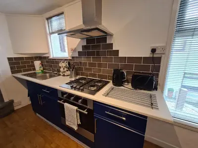 a kitchen with a sink and a stove top oven at Ty Morgan's Apartments in Rhayader