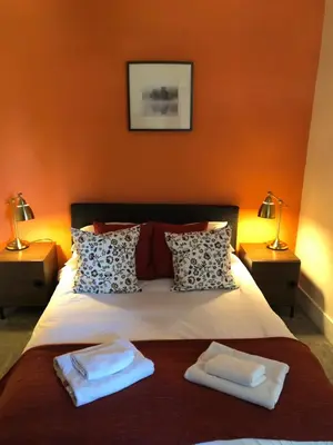 a bedroom with a bed with two towels on it at Ty Morgan's Apartments in Rhayader