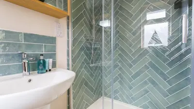 a bathroom with a sink and a glass shower at Swn y Mor in Harlech