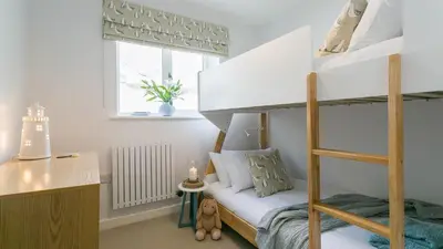 a bedroom with a bunk bed and a desk at Swn y Mor in Harlech