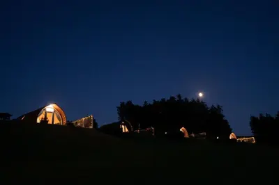 a view of a observatory at night with the moon at Aberystwyth by Wigwam Holidays in Aberystwyth