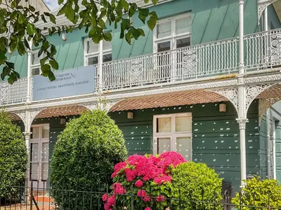 a green building with a balcony and pink flowers at Uk47787 - Flat 5E in Aberystwyth