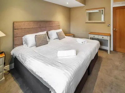 a bedroom with a large bed with white sheets at Uk47787 - Flat 5E in Aberystwyth