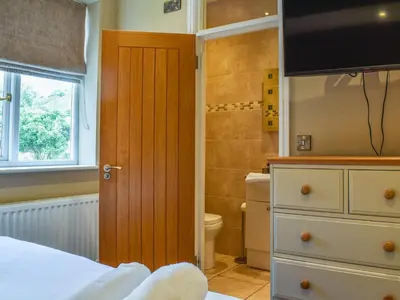 a bedroom with a bed and a television and a bathroom at Uk47787 - Flat 5E in Aberystwyth
