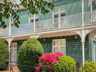 a green building with a balcony and pink flowers at Uk47786 - Flat 4E in Aberystwyth