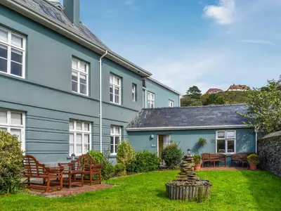 a house with a yard with chairs and a stone statue at Flat 3E - Uk47858 in Aberystwyth