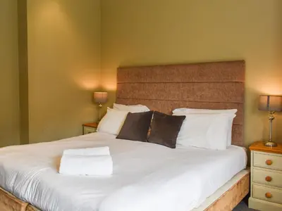 a bedroom with a large white bed with two lamps at Flat 3E - Uk47858 in Aberystwyth