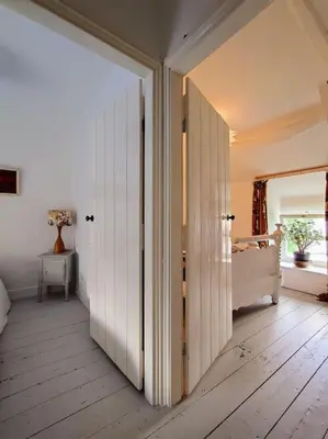a bedroom with a door open to a bedroom with a bed at Cosy Welsh Town Cottage in Brecon