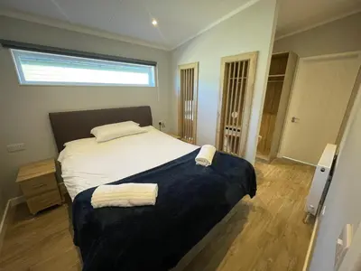 a bedroom with a bed with two towels on it at Mountain View Brown lodge in Aberystwyth