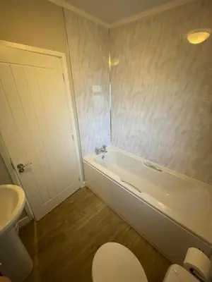 a bathroom with a tub and a toilet and a sink at Mountain View Brown lodge in Aberystwyth
