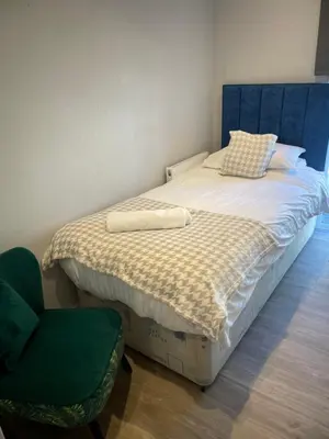 a small bedroom with a bed and a chair at Mountain View Brown lodge in Aberystwyth