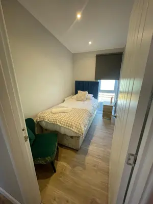 a small bedroom with a bed and a chair at Mountain View Brown lodge in Aberystwyth