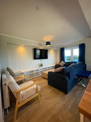 a living room with a blue couch and a tv at Mountain View Brown lodge in Aberystwyth