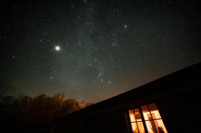 a starry night with the milky way over a house at Owl Cabin in Llanbrynmair