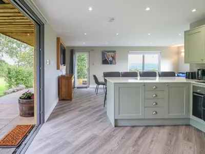 a kitchen with a counter and a dining room at Orchard Lodge in Corwen