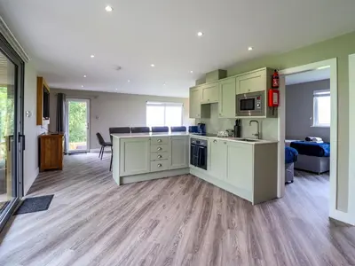 a kitchen with white cabinets and a counter top at Orchard Lodge in Corwen
