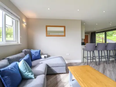a living room with a couch and a table at Orchard Lodge in Corwen