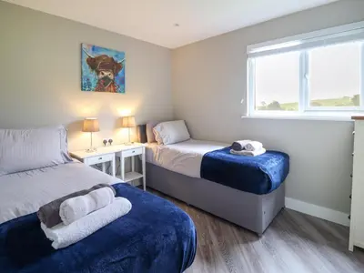 a small bedroom with two beds and a window at Orchard Lodge in Corwen
