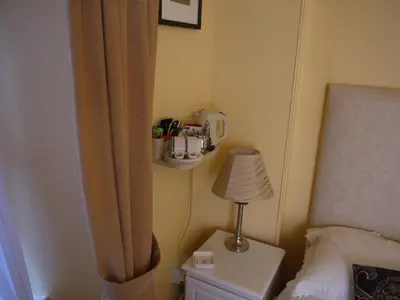 a bedroom with a bed with a curtain and a lamp at Ivy House B&B in Dolgellau