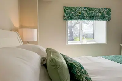 a bedroom with a bed with pillows and a window at Marrington Lodge in Chirbury