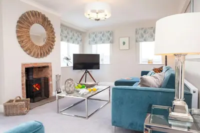 a living room with a blue couch and a fireplace at Marrington Lodge in Chirbury