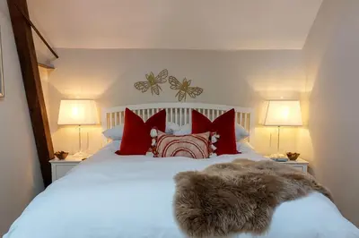 a bedroom with a white bed with red pillows at The Annexe in Chirbury