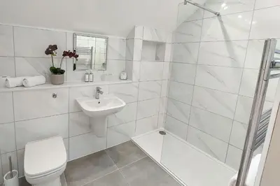 a white bathroom with a toilet and a sink at The Annexe in Chirbury