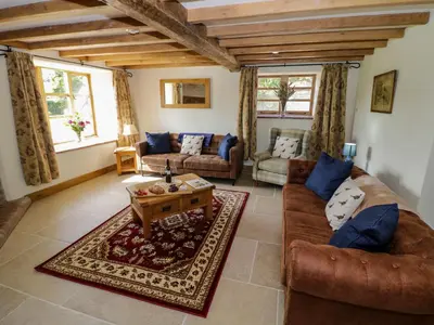 a living room with two couches and a coffee table at Grove Farm in Church Stretton