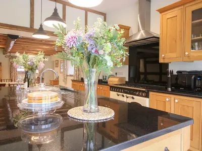 a kitchen with a vase of flowers on a counter at Grove Farm in Church Stretton